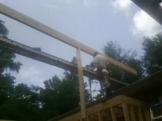 Carpenter setting a ridge beam over a new addition frame — Ice Dam Removal by Roofing Brothers in Escalon
