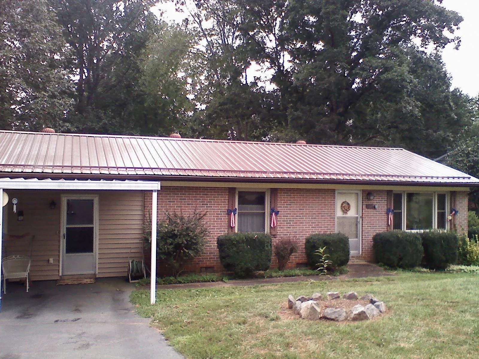 Bronze metal roof and carport on a brick ranch home — Roof Repair work by our crew in Escalon