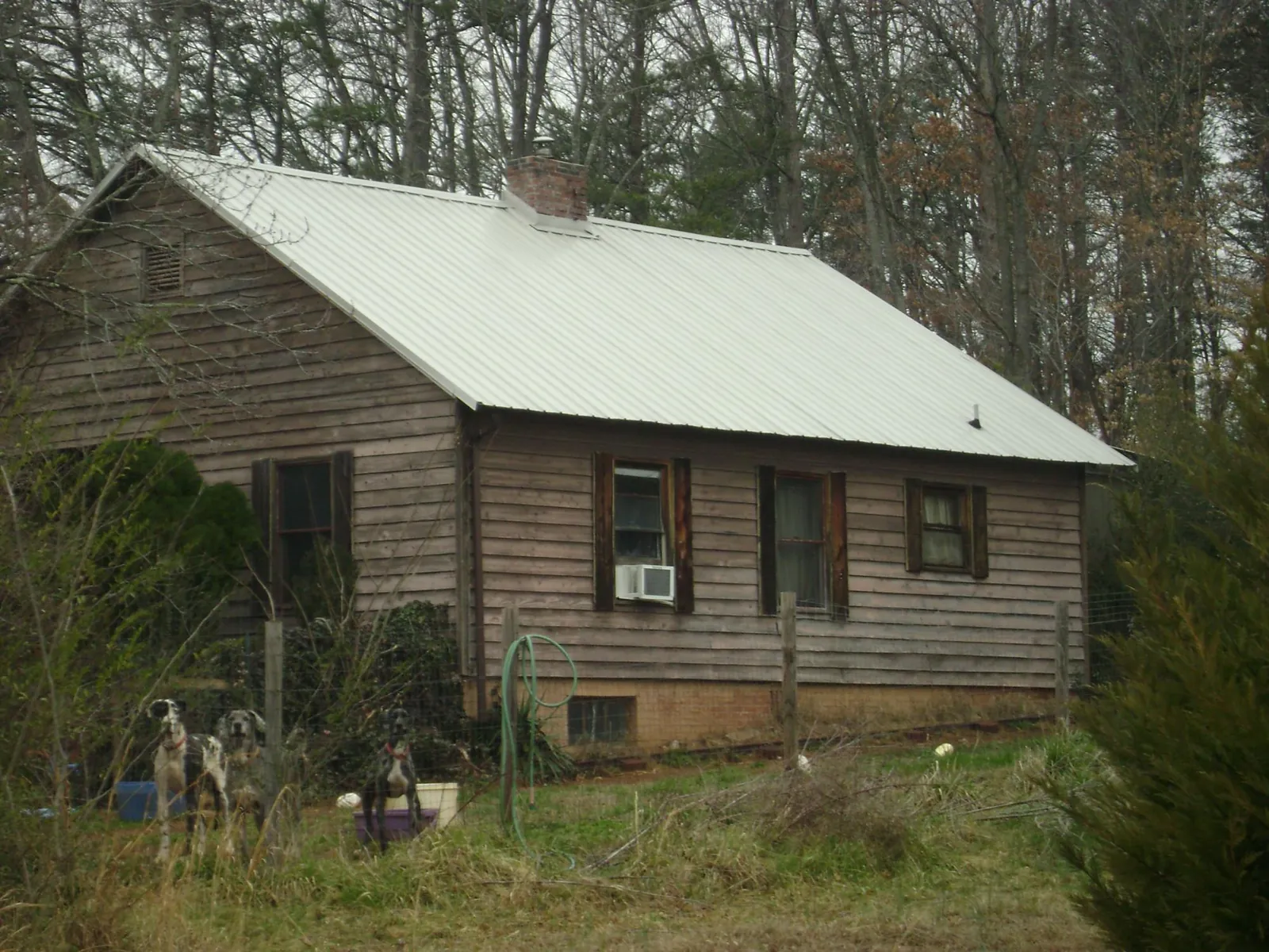 White metal roof on an old wood sided farmhouse, from a Metal Roof Installation job in Escalon